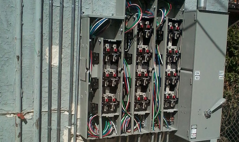 electrician working on panel with brakers